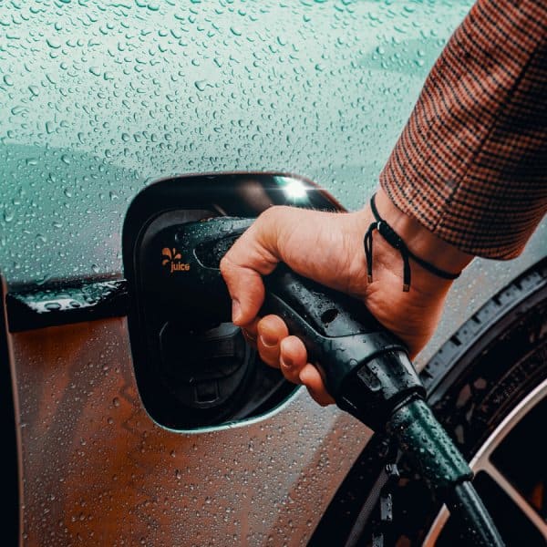 Un homme recharge son véhicule électrique